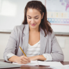 A woman writing notes at her desk